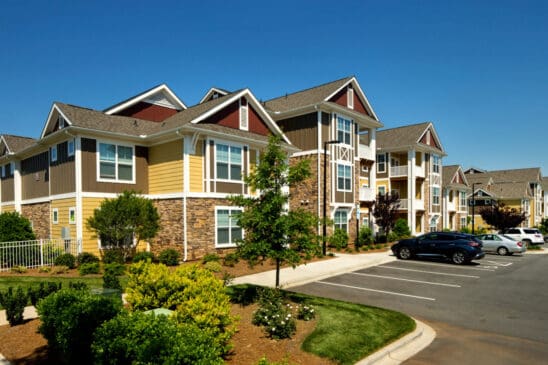 Modern apartment complex with parking lot and landscaping