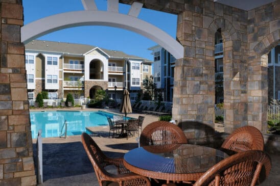 Apartment complex pool with patio seating and arches