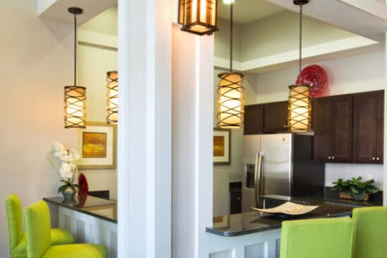 Modern kitchen bar with green stools and pendant lights