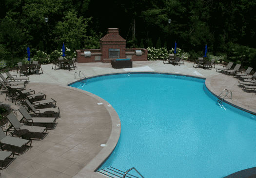 Outdoor curved swimming pool with lounge chairs