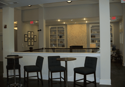 Modern lounge area with chairs, tables, and shelves
