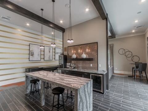 Modern home bar with marble island and pendant lighting