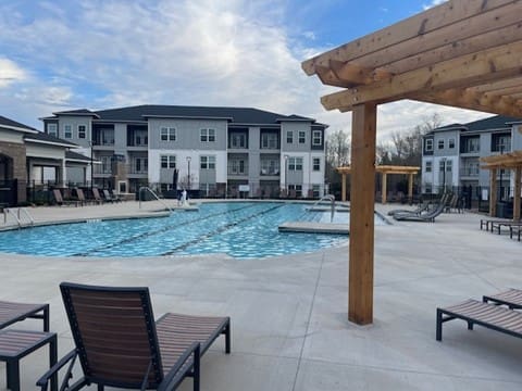 Apartment complex courtyard with outdoor swimming pool and lounge chairs