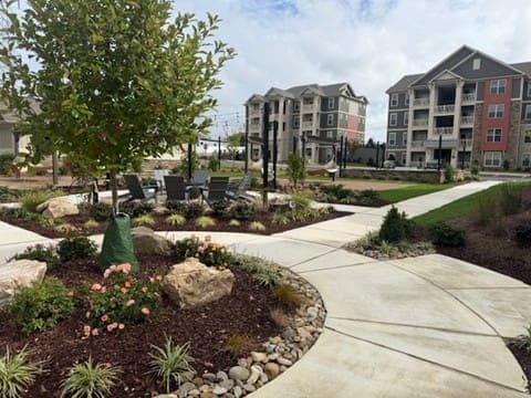 Landscaped apartment complex courtyard with walkways and trees