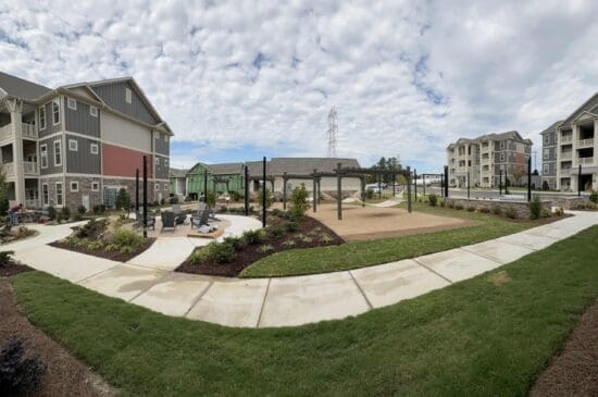 Modern apartment courtyard with hammocks and landscaped lawn