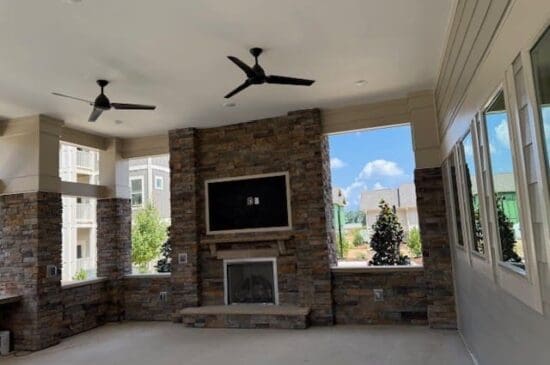 Covered patio with stone fireplace and ceiling fans