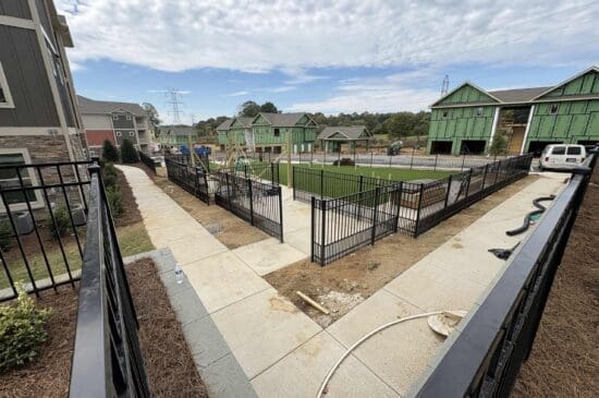 Apartment complex courtyard with fenced playground under construction